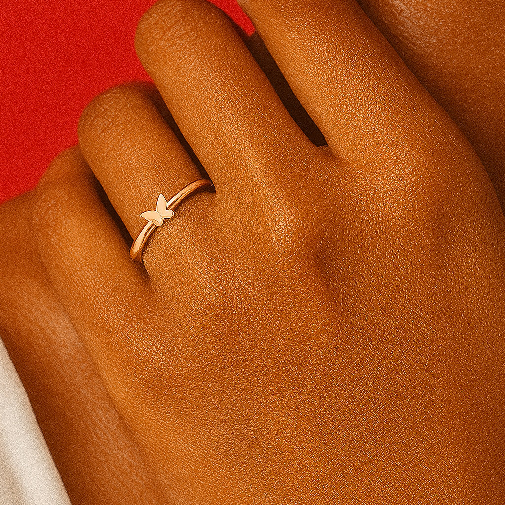 Gold ring with a star design on a person's finger against a red background “Delicate gold ring with a small butterfly design on a person’s hand over a red background”