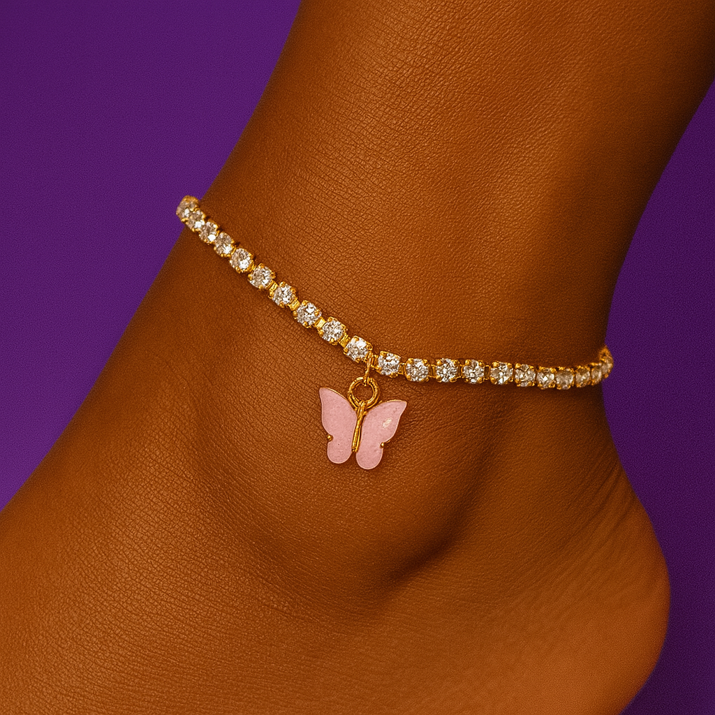Gold bracelet with a pink butterfly charm on a wrist against a purple background "Gold anklet with crystal stones and pink butterfly charm worn on a person’s ankle with a purple background"
