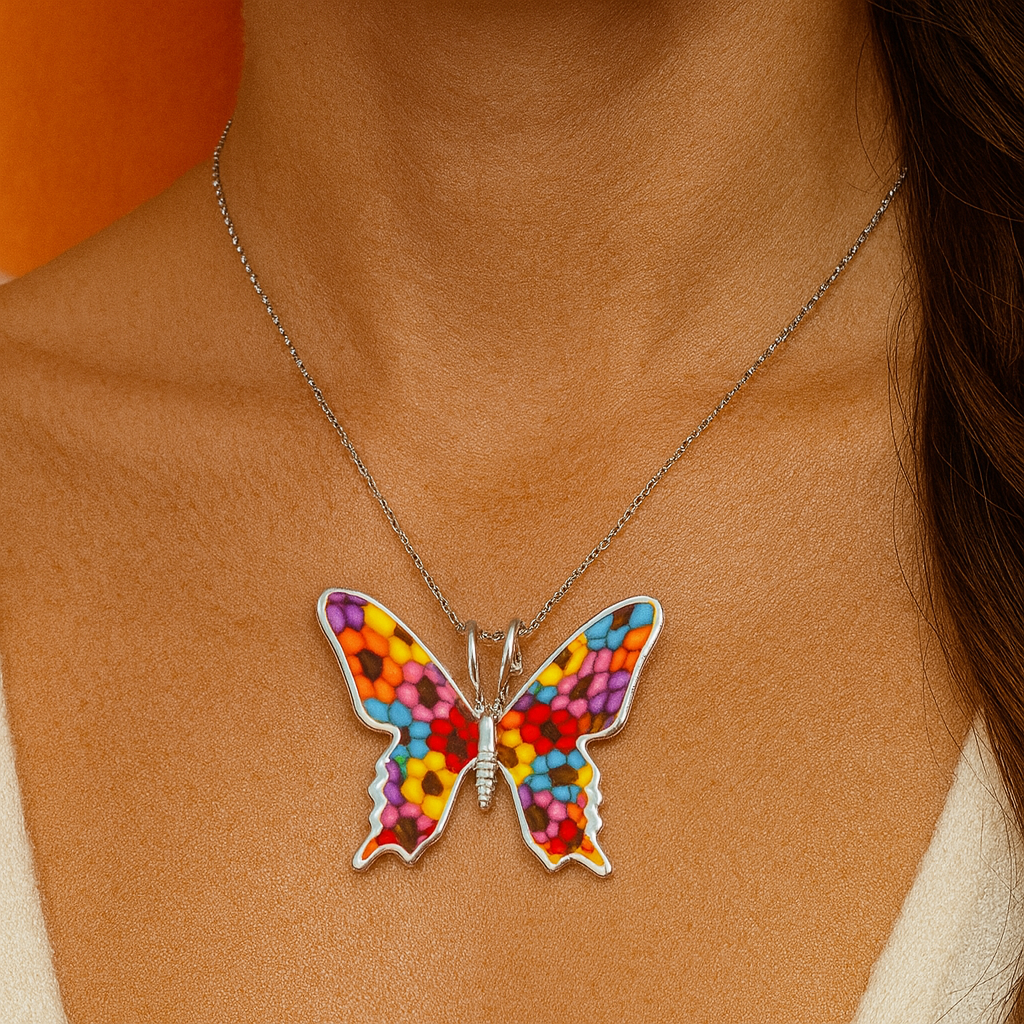 Colorful butterfly pendant necklace on a person's neck with an orange background