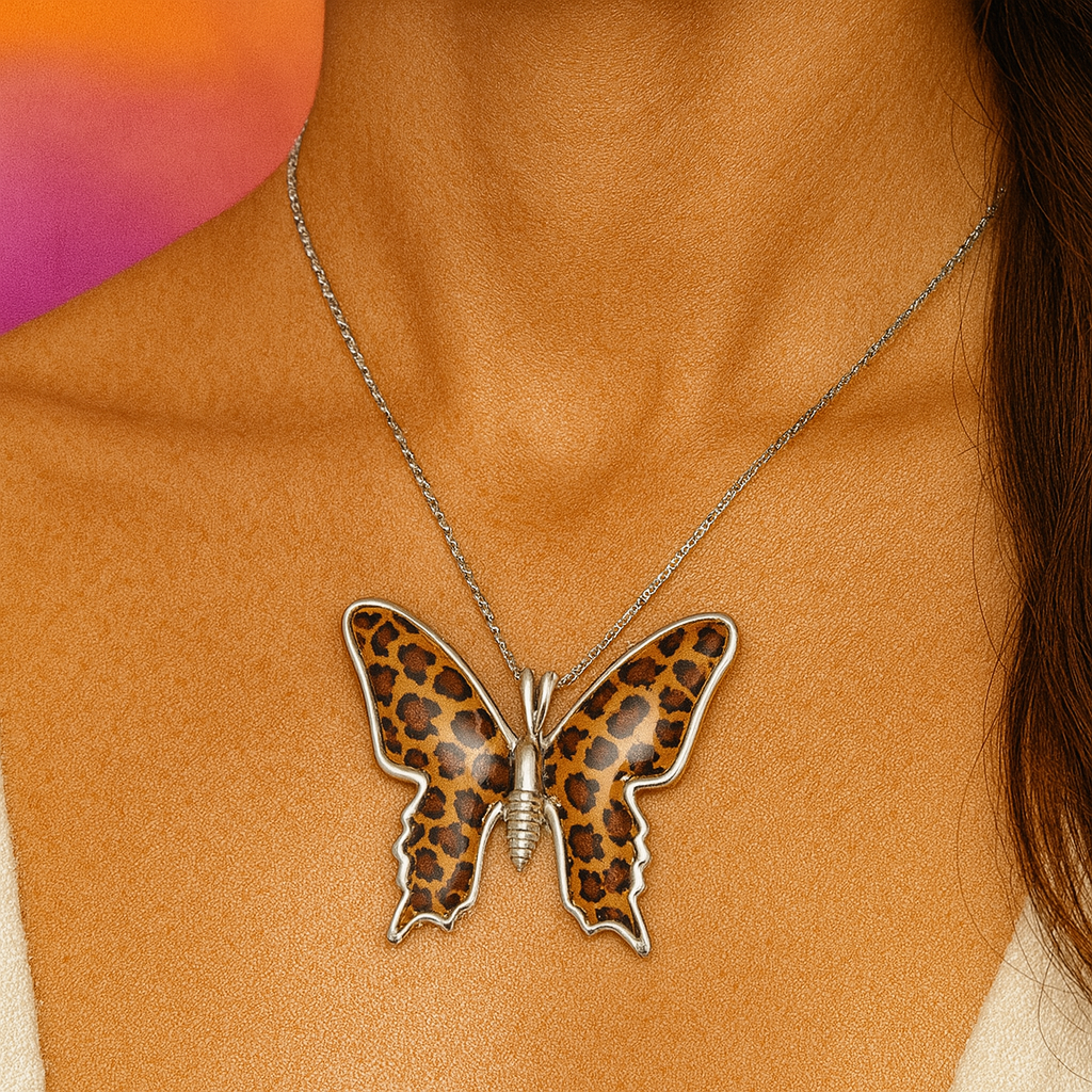 Butterfly necklace with leopard print design on a person's neck against a blurred background
